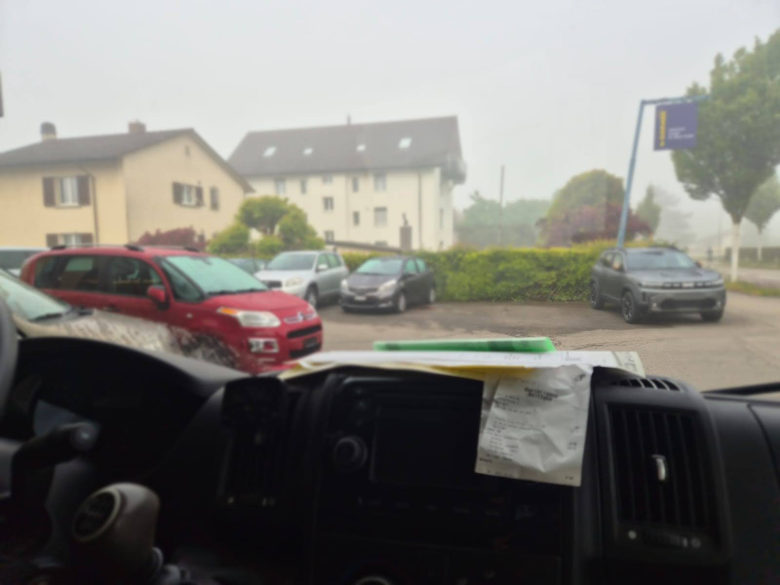 Ein völlig verknitterter und halb verblichener Kassenbon liegt auf dem Armaturenbrett eines Transporters